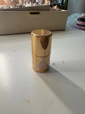 CAIA highlighter stick Pearl - Säljer en highlighter stick från CAIA i nyansen Pearl. Förpackningen är guldig och cylinderformad med ett stilrent utseende. Highlightern ger ett skimrande glow och är enkel att applicera tack vare stickformatet. Perfekt för att framhäva ansiktets drag.