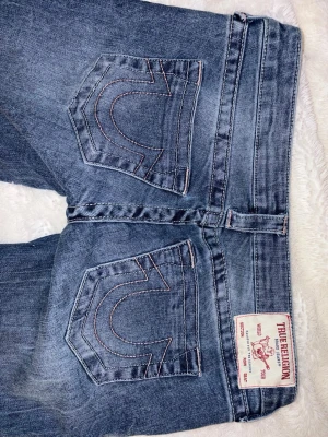 True religion low waist - True religion jeans i modellen ultra low rise joey flare SN, storlek 27! De är väldigt lågmidjade.  Använda en gång, för stora för mig.  De är stretchiga, och innerbenslängden är ca 82, tvärsöver midjan är det ca 40cm, och grenhöjden är typ 18cm! Är intresserad av byte mot true religion jeans, gärna 25, 26 elelr 27 i annan modell
