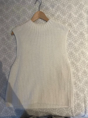 Vit stickad väst från Selected Femme - Säljer en snygg vit stickad väst från Selected Femme. Västen har en hög krage och är ribbstickad. Storlek står ej men skulle säga s