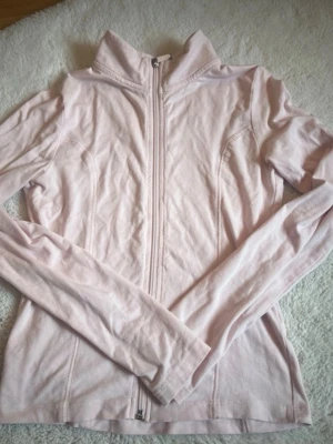 Ljusrosa ziptröja 💘 - Säljer en ljusrosa ziptröja med hög krage och långa ärmar. Tröjan har hel dragkedja framtill och är tillverkad i ett mjukt, stretchigt material som känns skönt mot huden. Perfekt för lager på lager och enkel att matcha med olika outfits.