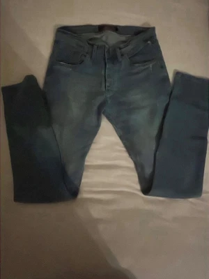 Blå slim fit jeans Hugo boss - Snygga blå slim fit jeans med klassisk femficksdesign och normal midja. Jeansen har en lätt tvättad look och raka ben. Perfekta för en avslappnad och trendig stil.
