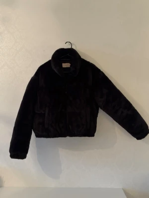 Svart fuskpälsjacka från Nelly - Säljer en svart, fluffig fuskpälsjacka från Nelly i storlek 36.  Perfekt för att hålla värmen och se stylish ut. Jätte skön och mysig. Topp skick 