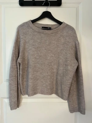 Beige stickad tröja från 157 - Mysig beige stickad tröja från 157 med rund halsringning och långa ärmar. Tröjan har en enkel, rak passform och ribbstickade muddar vid hals, ärmslut och nederkant. Perfekt för lager på lager och en avslappnad stil. Köpt på plick men var lite för liten.