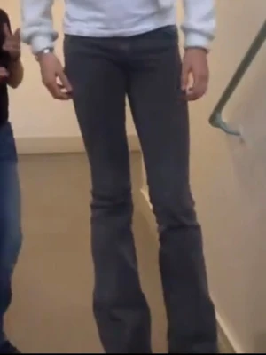 Grå bootcut jeans med hög midja - Säljer ett par grå bootcut jeans med hög midja och klassiska fem fickor. Jeansen har en snygg tvättad look och är tillverkade i denim med stretch för skön passform. Perfekt för dig som gillar retrostil och vill ha ett par jeans som sticker ut.