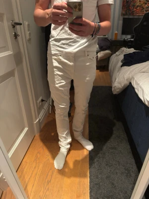 Vita slim fit jeans Tommy Hilfiger - Säljer ett par vita slim fit jeans med smal passform. Jeansen har normal midja och är tillverkade i ett stretchigt material för extra komfort. Perfekta för dig som vill ha en clean och stilren look. Storlek 176