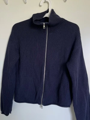 Navy stickad ziptröja Bikbok - Mörkblå stickad tröja från BikBok med grov ribbstickning och hög krage. Tröjan har en silverfärgad dragkedja framtill och långa ärmar. Nyskick❤️