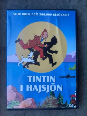 Tintin i hajsjön dvd - DVD-film med Tintin i Hajsjön. Filmen har svenskt tal med röster av John Harryson, Thomas Bolme, Bert-Åke Varg och Kerstin Dellert m.fl. Bildformat 1.33:1, ljud mono. Speltid 1 timme 14 minuter.  Finns på språk: Svenska   OBS!! skivorna är begagnade så det kan förekomma repor/hairlines på skivorna, men då jag kollar igenom alla filmer jag säljer garanterar jag att alla funkar felfritt om inget annat står! :)