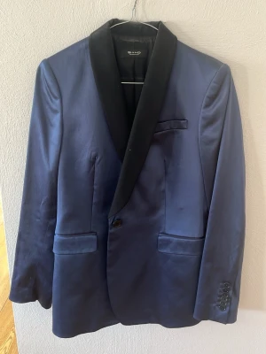 SAND Copenhagen blå smokingkavaj med svarta revers - Säljer fin blå smokingkavaj från SAND Copenhagen med svarta satinrevers. Klassisk och elegant modell perfekt för fest, bröllop eller nyårsafton! ✨ Mycket bra skick, använd fåtal gånger. Bra kvalitet och snygg passform. Frågor? Skriv gärna och be om fler bilder! Kan skickas snabbt 😊