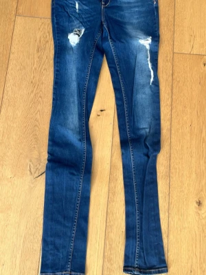 2nd Day distressed jeans med revor  - Säljer snygga 2nd Day jeans med coola distressed-revor på knän och lår. Bra stretch och fin passform. Använda men fortfarande i bra skick! ✨ Danskt kvalitetsmärke. Perfekta till vardag eller feststyling. Frågor? Skriv gärna! Kan skickas snabbt 😊