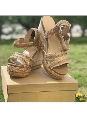 Flätade kilklackssandaler i naturfärg - Snygga sandaler med kilklack och flätade remmar i naturfärgat material .  Sandalerna har öppen tå, justerbart spänne vid ankeln och en stadig platåsula. Perfekta för sommarens alla outfits och ger extra höjd med sin trendiga espadrille-look med guldtråd i platåsula. 