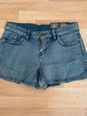 Nya. Blå jeansshorts med klassisk passform - Snygga blå jeansshorts från Montana med klassisk femficksdesign, bälteshällor och knappgylf. Shortsen har en normal passform och är tillverkade i bomull med lätt stretch för extra komfort. Perfekta för varma sommardagar.