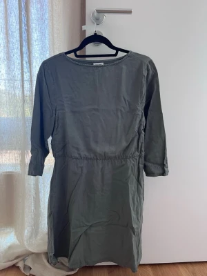 Grön klänning från Bubbleroom - En enkel och stilren grön klänning från Bubbleroom med trekvartsärm och rund halsringning. Klänningen har en rak passform och är tillverkad i ett mjukt bomullsmaterial, perfekt för en avslappnad look.