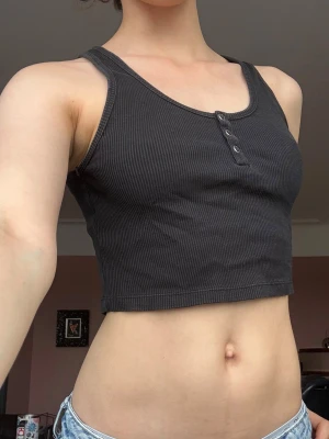 Svart ribbad croppad linne - Jätte söt topp med tre knappar framtill som går att öppna. Buda gärna priser!