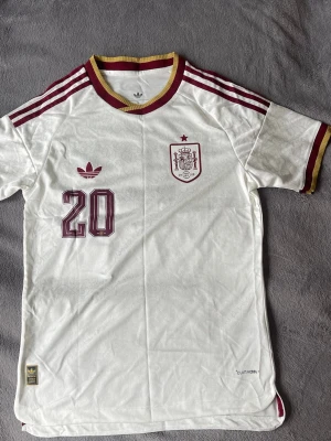 Spanien Pedri #20 bortatröja  - Säljer en riktigt clean Spanien-tröja med Pedri #20 på ryggen. Vit/guldig färgcombo med sjuka detaljer i tyget och retro känsla 🔥  • Spanien landslag 🇪🇸 • Pedri #20 • Storlek L • ClimaCool • Snygga detaljer och struktur i materialet • Perfekt fit till vardag eller fotboll  Riktigt fet och ovanligare än vanliga hemmatröjan 👌  💰 Pris: 449 kr 📍 skickas  