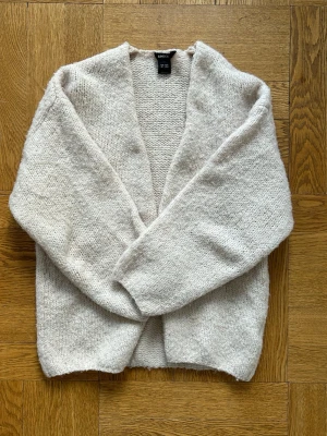 Stickad kofta från Lindex - Mysig beige stickad kofta från Lindex. Perfekt till alla årstider. Tror också att denna färgen på koftan inte går att köpa på Lindex längre