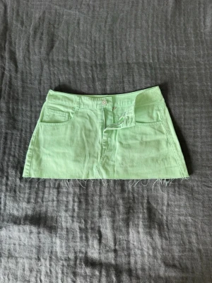 Mintgrön kjol från Clockhouse - Jätte snygg lågmidjad jeanskjol i neon grönt med fransig kant! Perfekt inför sommaren och skönt material, fråga om mått. 