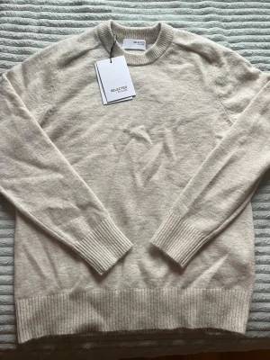 Beige stickad tröja från Selected - Helt ny stickad tröja från Selected Homme. Aldrig använd, prislapp kvar. Nypris 900