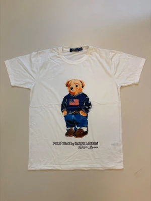 Ralph Lauren polo Björn t-shirt - Vit Ralph Lauren Polo bear T-shirt // mycket bra skick aldrig använda // storlek M // mått, längd 65cm Axelbredd 41cm // Skriv vid minsta fråga eller fundering🤝