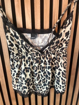 Leopardmönstrad topp från Gina Tricot - Säljer en snygg leopardmönstrad topp från Gina Tricot med tunna axelband och svarta spetsdetaljer🐆💓