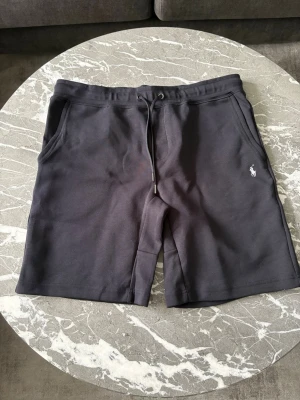Ralph Lauren Shorts - Babyblåe shorts från Ralph Lauren, i princip nyskick och sällan använda. Inga defekter eller sånt liknande. Storlek XL men passar L bättre skulle jag säga. Vid frågor hör av dig!