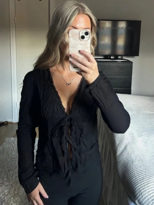 Svart blus med knyt och spetsdetaljer - Svart blus med knyt och spetsdetaljer från Zara. Storlek S. Pris: 100kr. Oanvänd, mycket bra skick. Skriv meddelande om det önskas fler bilder eller om det är några funderingar. 💛