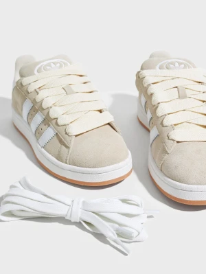 Adidas’s Campus 00s - Snygga sneakers från Adidas i beige mocka med klassiska vita ränder på sidorna och vit logga på plösen. Skorna har tjocka vita skosnören och en vit sula med gummidetalj. Perfekta för en clean och stilren look. Har endast använt dessa några gånger och är köpta nu i våren🥰 superfina nu till sommaren! Vita, lite tunnare snören ingår i skolådan🦋