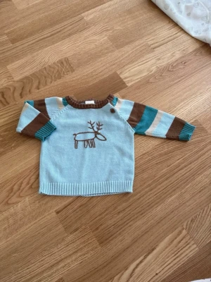 Tröja stl 62 bebis  - Stickad tröja med en broderad älg på.  Storlek 62. Från Friends. 100% bomull.
