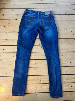 Nudie jeans  - Snygga Nudie jeans i modell Skinny Lin. Jeansen är i blå färg med en väldigt fin wash på dem. Storlek 30/32. Mycket gott skick, skriv vid eventuella funderingar😁  Fraktar inom 1-2 dagar  #nudiejeans #nudie #trending #skinnylin #nudieskinnylin #30/32 #archive #grisch #slimjeans #slimfit #nudieslimfit #fashion #y2k 