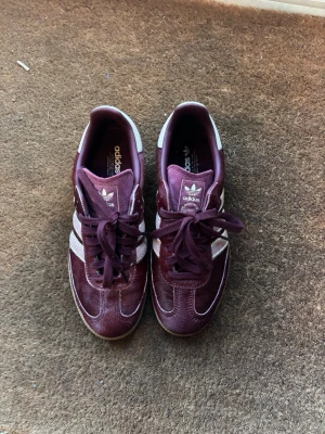 Vinröda Adidas sneakers - Snygga vinröda Adidas sneakers i storlek 38 och aldrig använda. Köpta för 3000kr. 