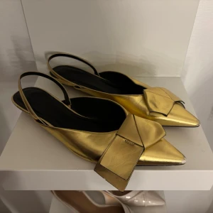 Pumps med kittenklack och stor rosett - Guldiga kittenheels med rosett i strl 39, använda vid endast ett tillfälle men har lite defekter framtill 💛