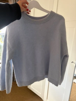 Ljusblå stickad tröja XS - Mysig ljusblå stickad tröja med rund halsringning och ribbade muddar vid ärmslut och nederkant. Tröjan har en avslappnad passform och är perfekt för lager på lager. Materialet känns mjukt och behagligt mot huden. Detta är hms ”finare tröjor” och köpte för ungefär 2 år sedan. 