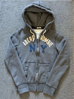 Vintage Abercrombie & Fitch Zip-Hoodie - Säljer denna riktigt snygga Abercrombie & Fitch koftan | Storlek S | Mycket bra skick | Längd≈67cm, Bredd armhåla-armhåla≈53cm | Model 175cm, 68kg | Hör av vid funderingar!