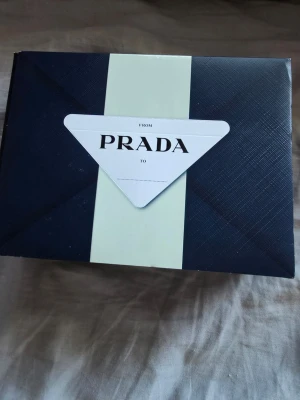 Prada Luna Rossa Black parfymset - Snyggt parfymset från Prada med Luna Rossa Black. Innehåller en svart, stilren parfymflaska på 50 ml och en smidig 10 ml reseflaska. Förpackningen är elegant i svart och vitt med Pradas klassiska design. Perfekt för dig som gillar exklusiva dofter.