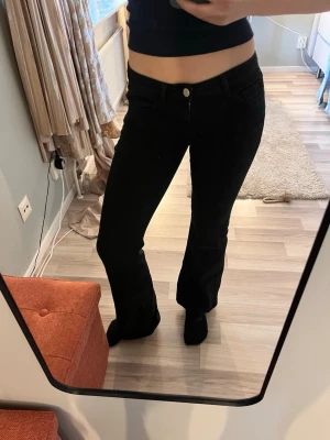 Svarta bootcut jeans från ONLY - Säljer ett par svarta lågmidjade bootcut jeans från ONLY. Materialet är mer mjukt än jeansmaterial så de är väldigt bekväma. Sällan använda så i fint skick! Pris kan diskuteras💕