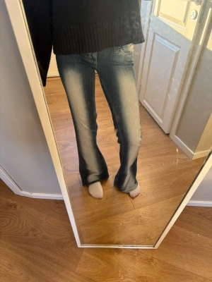 Blå bootcut jeans - Säljer ett par blå bootcut jeans med snygg ljus tvätt. Jeansen har klassisk femficksmodell och normal midja. Perfekta för dig som gillar en avslappnad men trendig look. Materialet är troligtvis bomullsdenim.