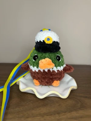 Virkad studenthänge - Virkad studenthänge/studenthalsband i form av en gräsand, cirka 9 cm hög☺️ Perfekt att ge bort på studenten!🥳