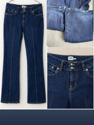 Mörkblå bootcut jeans från 157 - Säljer ett par mörkblå bootcut jeans från 157 med kontrastsömmar och klassisk femficksmodell. Jeansen har dubbla knappar i midjan och raka ben med lätt utsvängning. Perfekta för en avslappnad och trendig look.