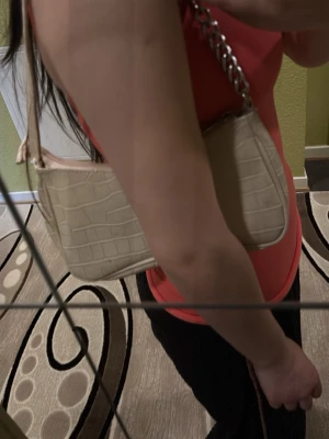 Beige axelväska med kedjedetalj - Snygg beige handväska med croco-mönster och silverfärgad kedja på axelbandet. Väskan har en stilren och modern design, perfekt för att lyfta din outfit. Materialet är konstläder med struktur och väskan har en avlång form.