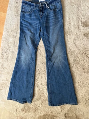 Blå ultra low flare jeans - Säljer ett par blå ultra low flare jeans från Ginatricot, aldrig använt 