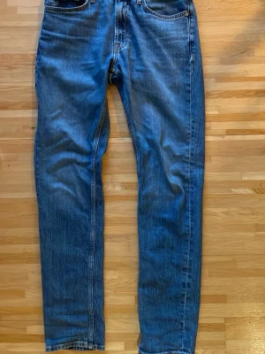 Blå regular jeans från Cubus, 28/32 - Säljer ett par klassiska blå jeans från Cubus i modellen regular fit, storlek 28/32. Jeansen har fem fickor, raka ben och är tillverkade i slitstark denim. Perfekta för dig som gillar en tidlös och enkel stil.