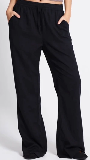 Svarta linnebyxor  - Svarta linnebyxor från lager 157 i modellen denise med avslappnad passform och resår i midjan. Byxorna har dragsko och är tillverkade i ett lätt och luftigt linnematerial, perfekta för varma dagar. Enkla att matcha med olika toppar för en chill look. Har haft länge o använt typ en gång.