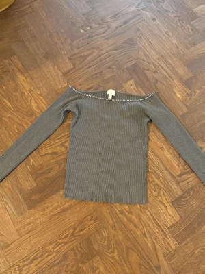 Jättesöt grå off-shoulder topp med silverstenar - Säljer denna snygga topp med silverstenar ifrån H&M. Storlek M men passar S också!! Jättebra skick. Skriv vid frågor/fler bilder osv osv.💕💕