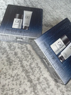 2st Armani Acqua di Giò presentset - Helt ny, Snyggt presentset från Giorgio Armani med Acqua di Giò. Innehåller en silverfärgad deodorant stick och en matchande duschgel i tub, båda med den klassiska fräscha doften. Förpackningen är elegant i blått och silver, perfekt för dig som gillar exklusiva doftprodukter.