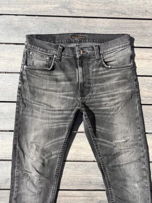 Nudie Jeans Archive grå - Nudie jeans med en galet fet fade och snygga slitningar! Fint skick inga tydliga defekter. Storlek 30/31 passar bra på dig som är runt 180. Modellen heter lean dean och sitter slim/regular. Kontakta mig för fler frågor och funderingar!
