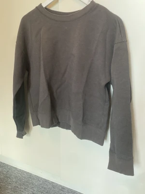 Grå sweatshirt från Uniqlo - En enkel och stilren mörkgrå sweatshirt från Uniqlo i storlek M🫶
