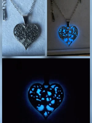 Handgjort självlysande halsband - Tree of life  - Snyggt handgjort halsband i silverfärgat rostfritt stål med ett hjärtformat hänge. Hänget har ett detaljerat trädmotiv i filigran och lyser blått i mörker. Vanligt dagsljus eller solljus aktiverar skenet i hänget och lyser vanligtvis upp till 12 timmar vid normal användning. Kedjan är tunn och justerbar. Perfekt accessoar för dig som gillar unika smycken med magisk känsla. Kedjans längd: 45 cm, Hängets storlek: ca 2 cm. Både hänget & kedjan tål vatten, missfärgas ej.