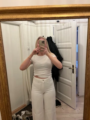 Vita jeans  - Säljer ett par vita jeans från Mango med vida ben och hög midja. Jeansen har två  fickor framtill. Sparsamt använda. 