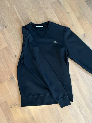 Svart sweatshirt från Lacoste - En stilren svart sweatshirt från Lacoste i storlek xs/s i bra skick.