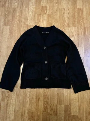 Svart stickad kofta - Svart stickad kofta med knappar och fickor i storlek xs, aldrig använd