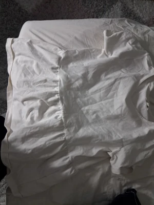 Vit kortärmad topp med volang - Söt vit topp med korta ärmar och volangdetalj nedtill. Toppen har rund halsringning och är tillverkad i mjukt bomullstyg. Perfekt för en avslappnad och trendig look.